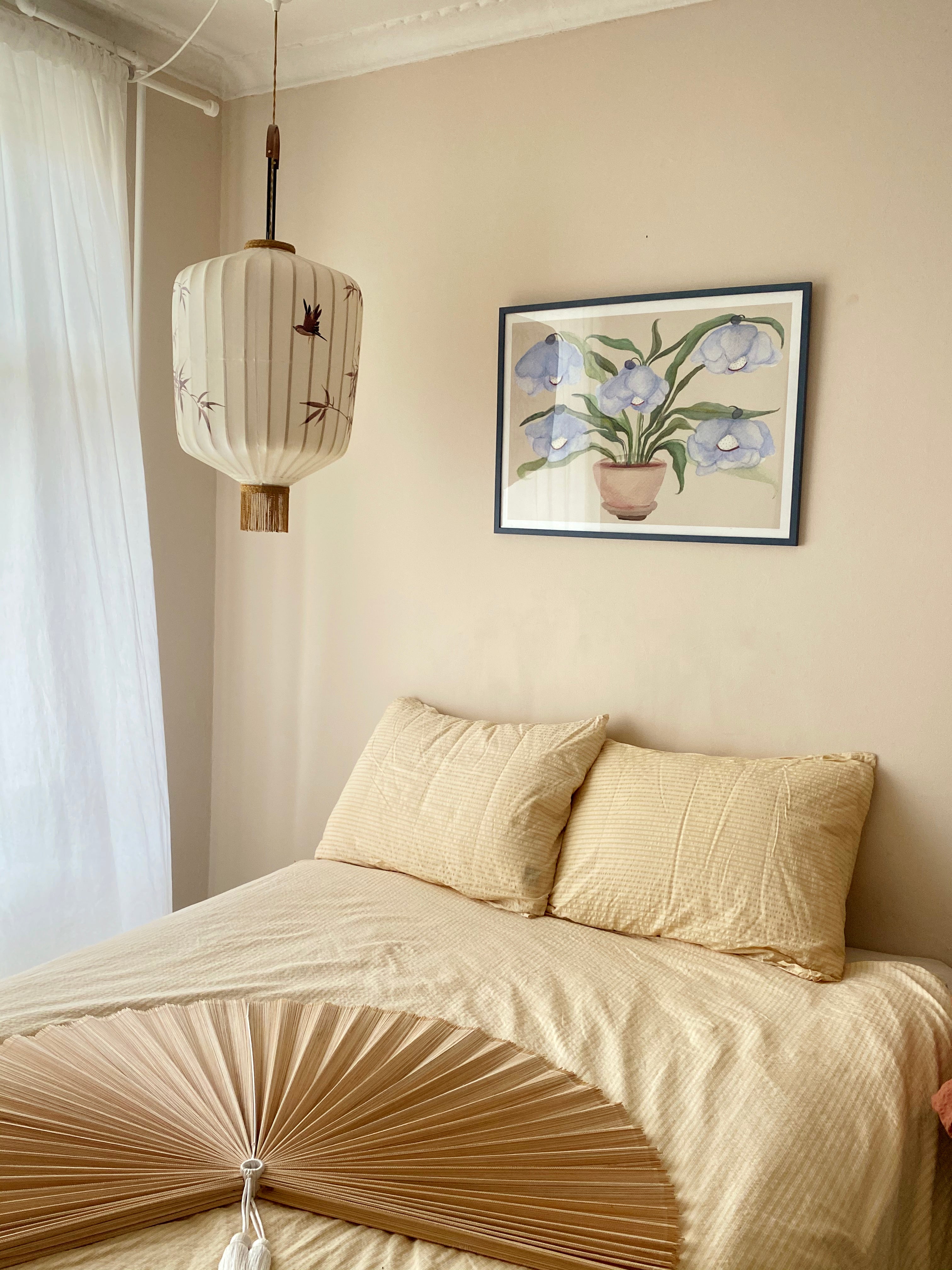 DESERT BLUEBELLS kunstplakat i mørk ramme over beige seng ved japansk pendellampe