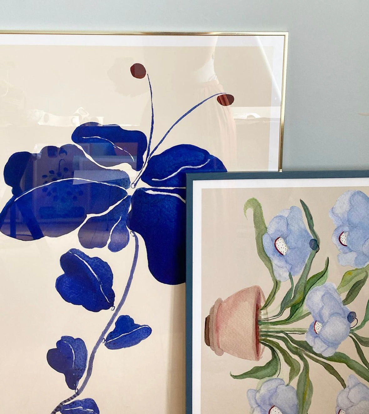Nærbillede af FLEUR DE BLEU kunstplakat sammen med en plakat med lyseblå blomster