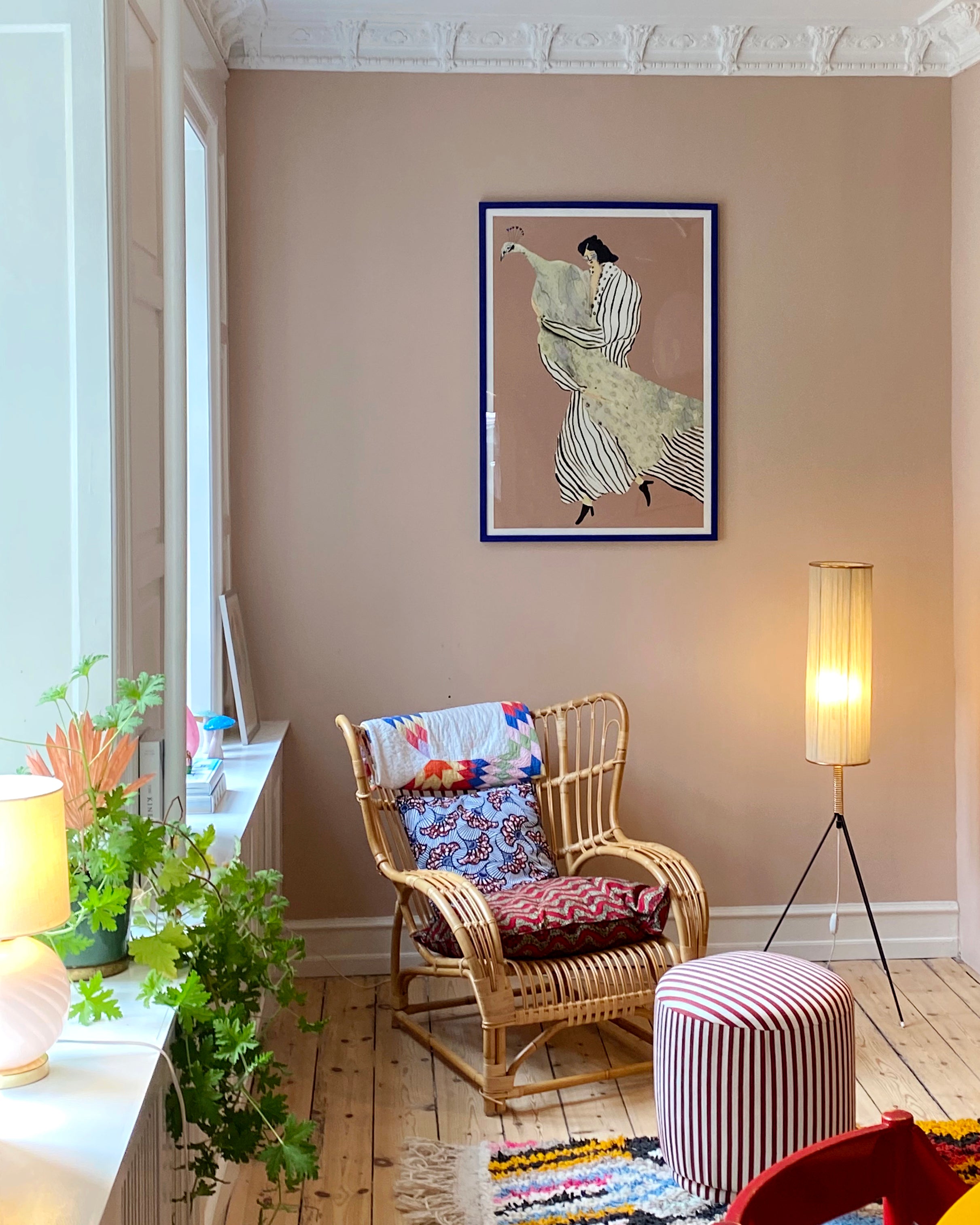 STOLEN PEACOCK kunstplakat med kvinde og påfugl i blå ramme over en fletstol