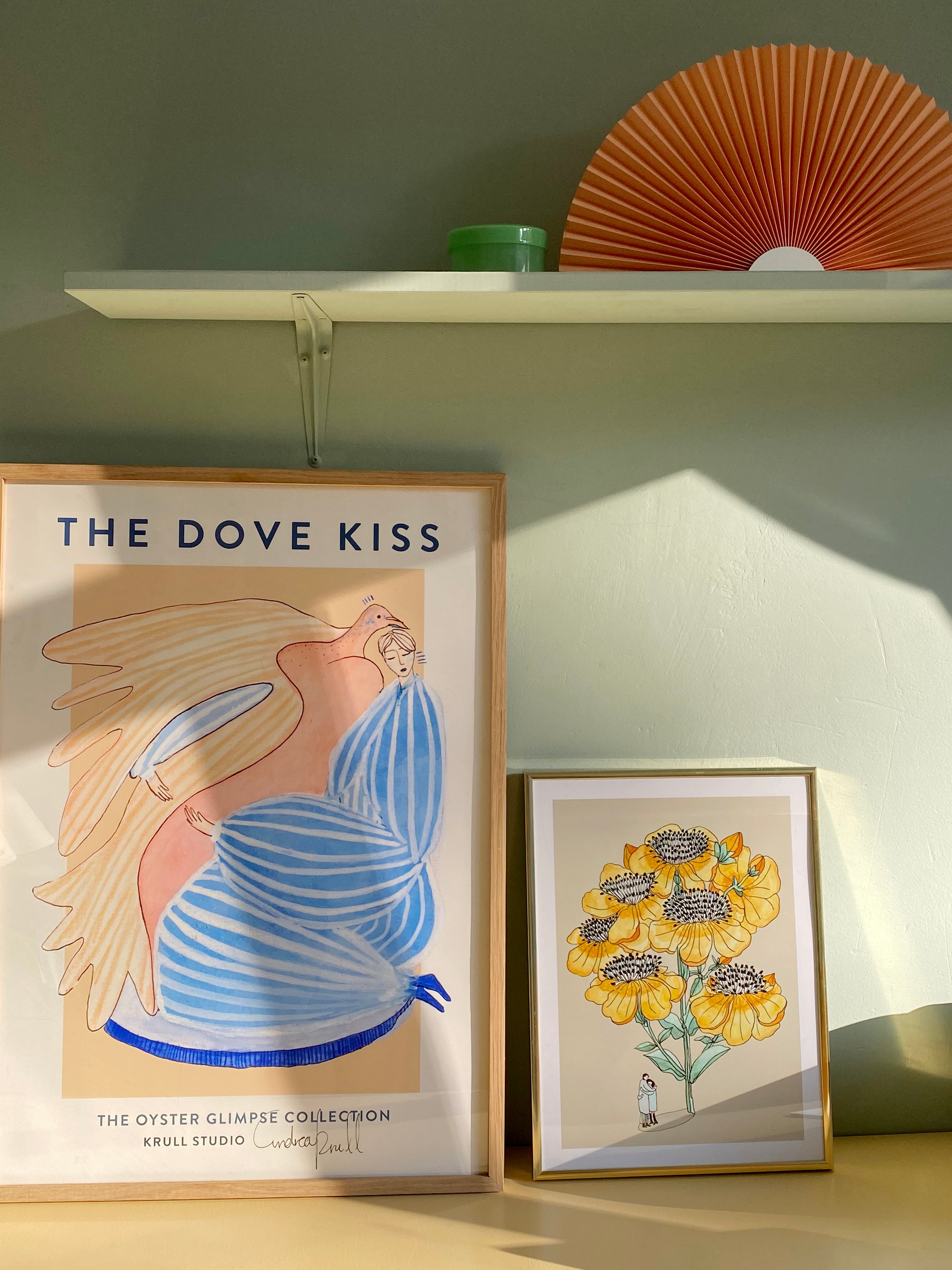HUG ME kunstplakat i lille messingfarvet ramme ved DOVE KISS på grøn væg