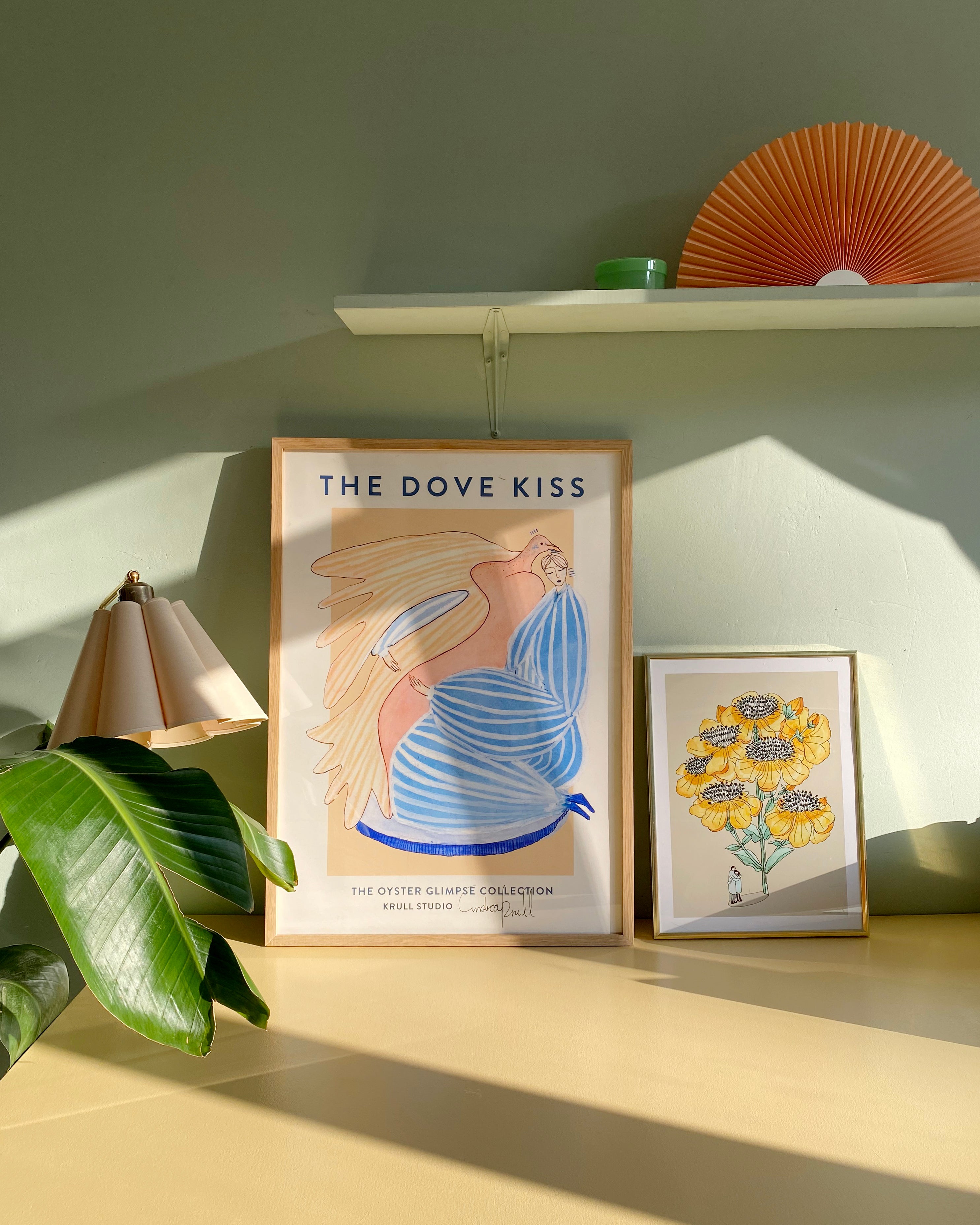 DOVE KISS kunstplakat i naturtræsramme på skab ved lille plakat med gule blomster