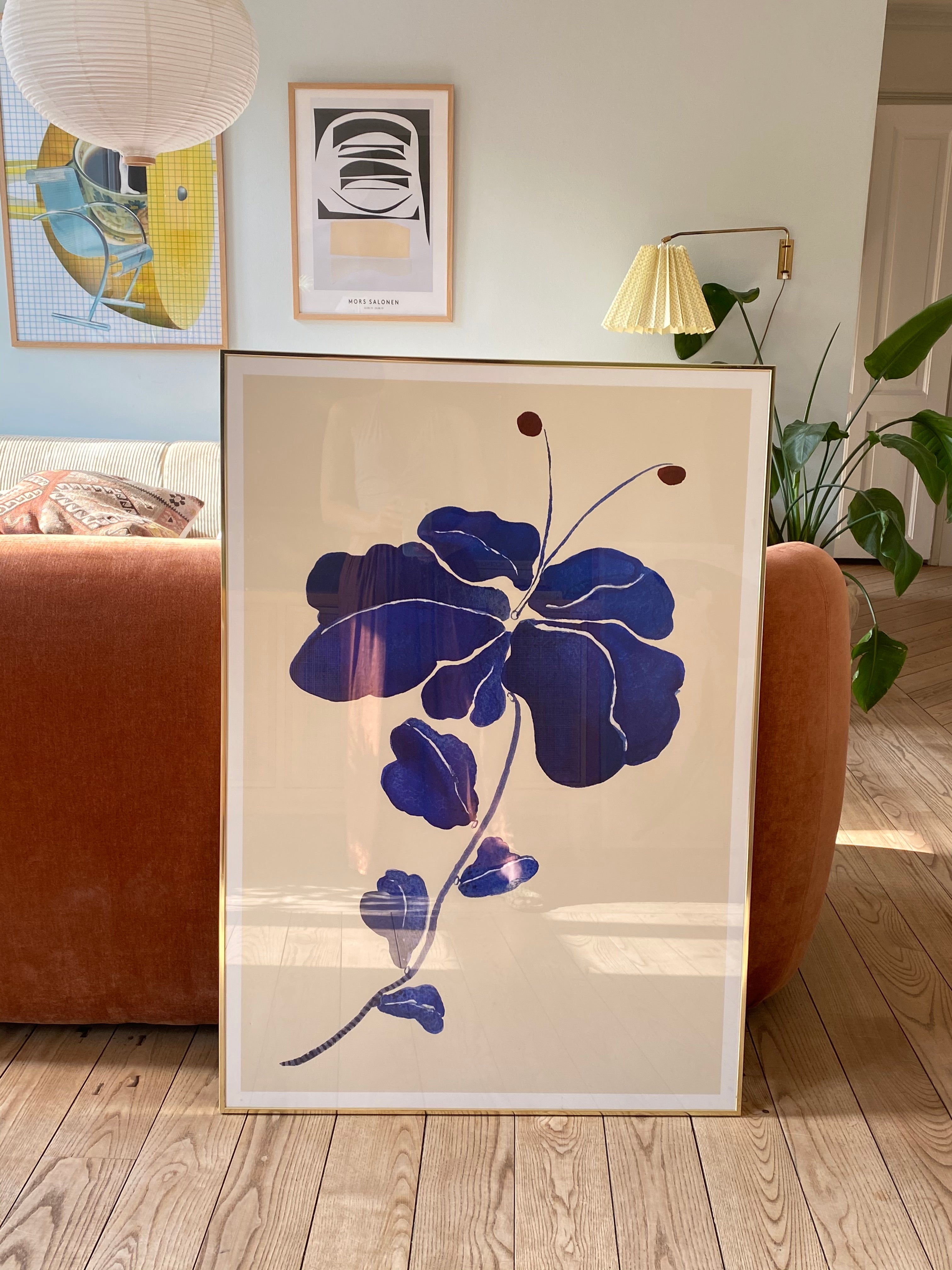 FLEUR DE BLEU kunstplakat med mørkeblå blomst foran en rosa sofa