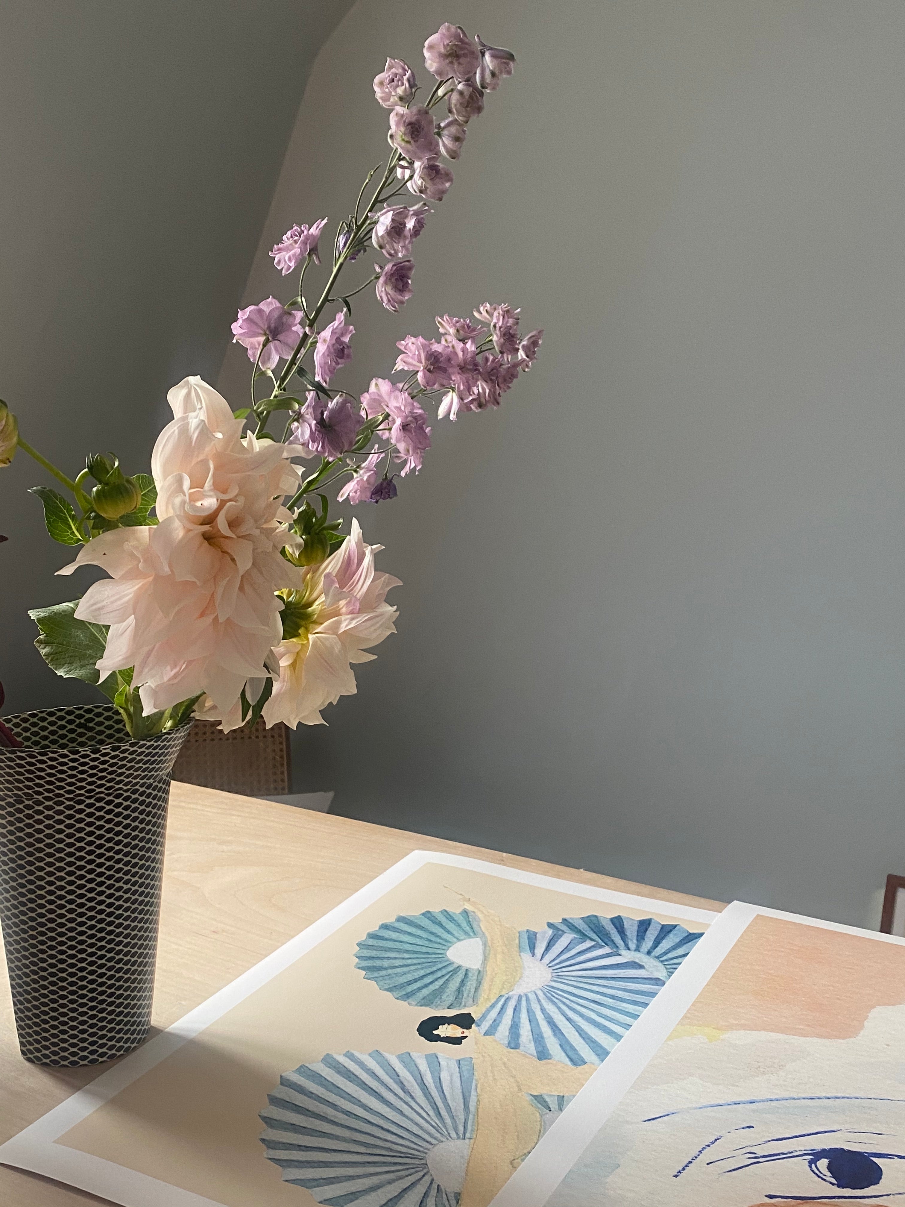 SENSU OGI kunsttryk med blå vifter på et bord ved en buket blomster