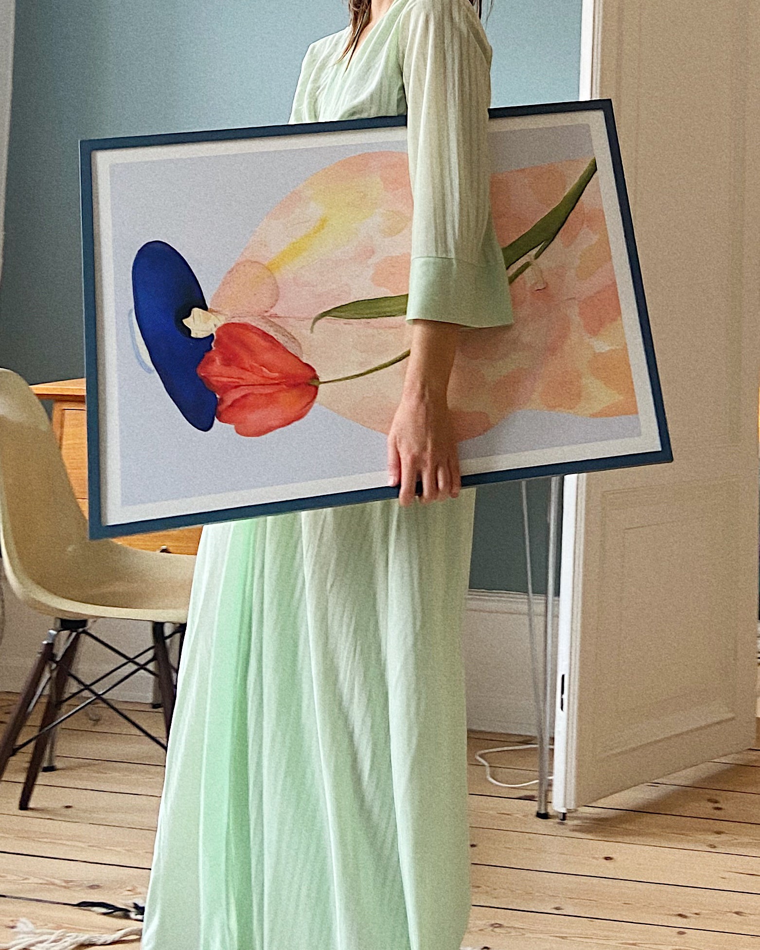 Person holder indrammet FRENCH TULIPS kunstplakat med rød tulipan og blå hat