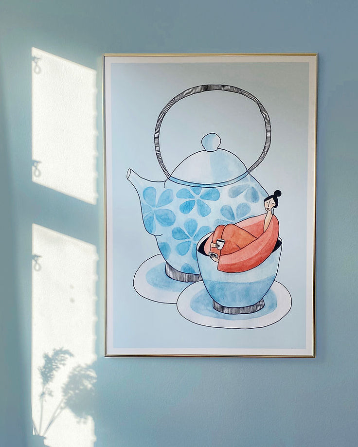 ROOIBOS kunstplakat i tynd messingfarvet ramme på lyseblå væg med sollys