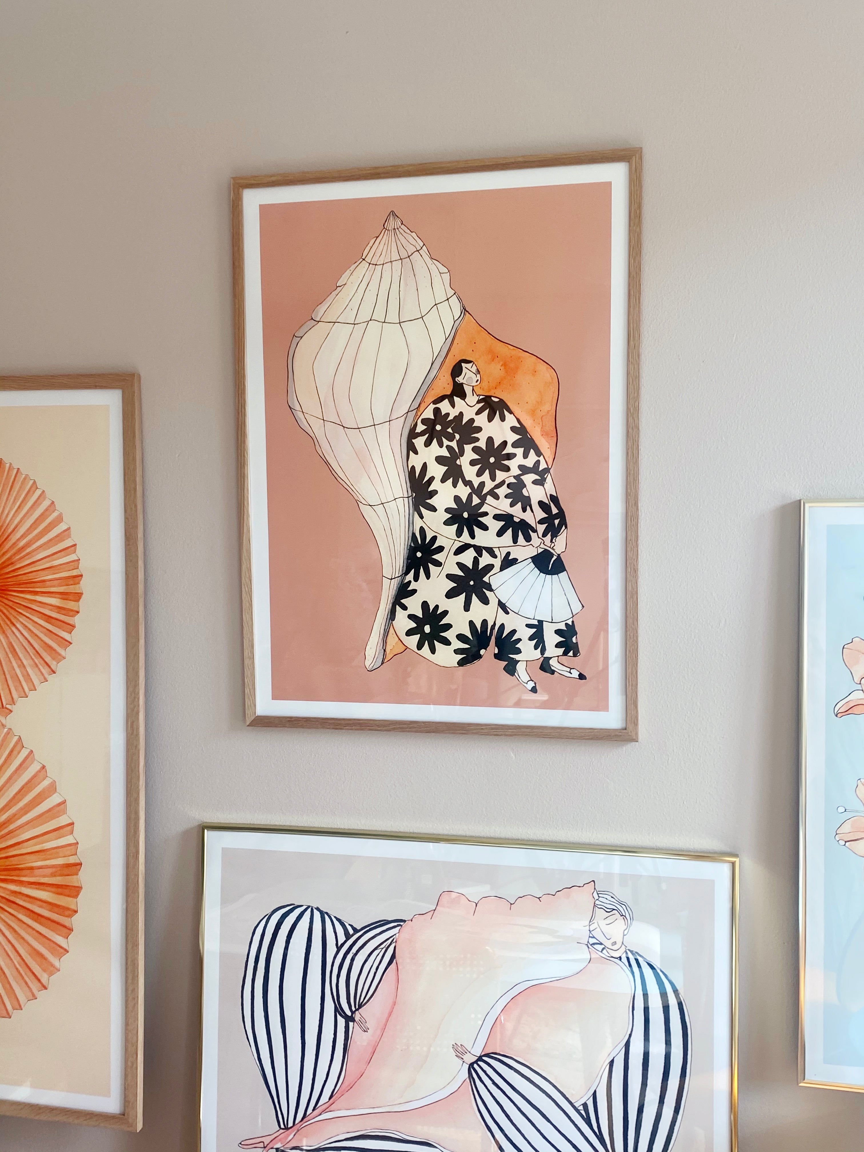 SEASHELL SOUNDS kunstplakat i naturtræsramme på gallerivæg med TANGERINES og HUG ME