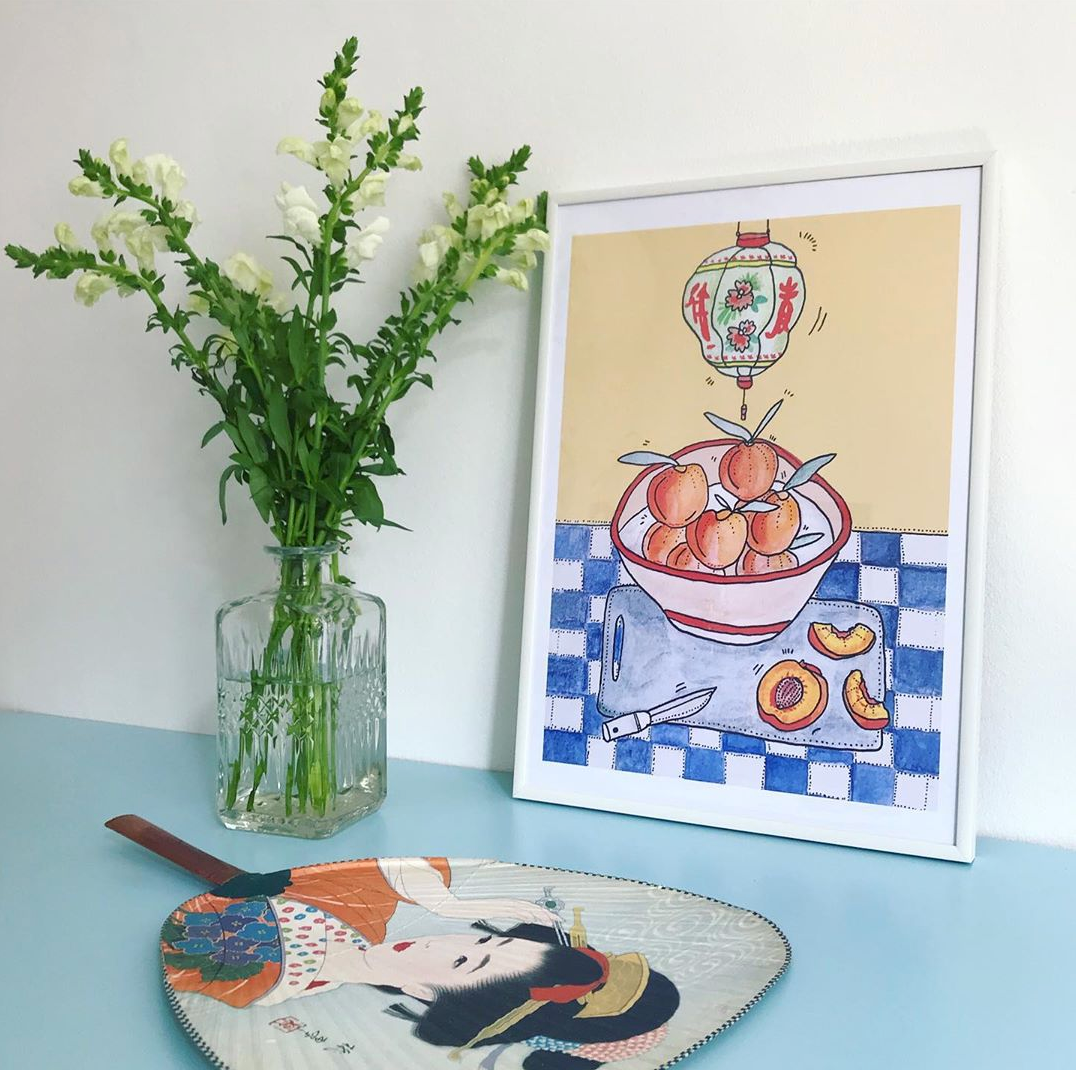 PEACH & BLUE TILES kunstplakat i hvid ramme på lyseblåt bord ved hvide blomster og dekorativ vifte