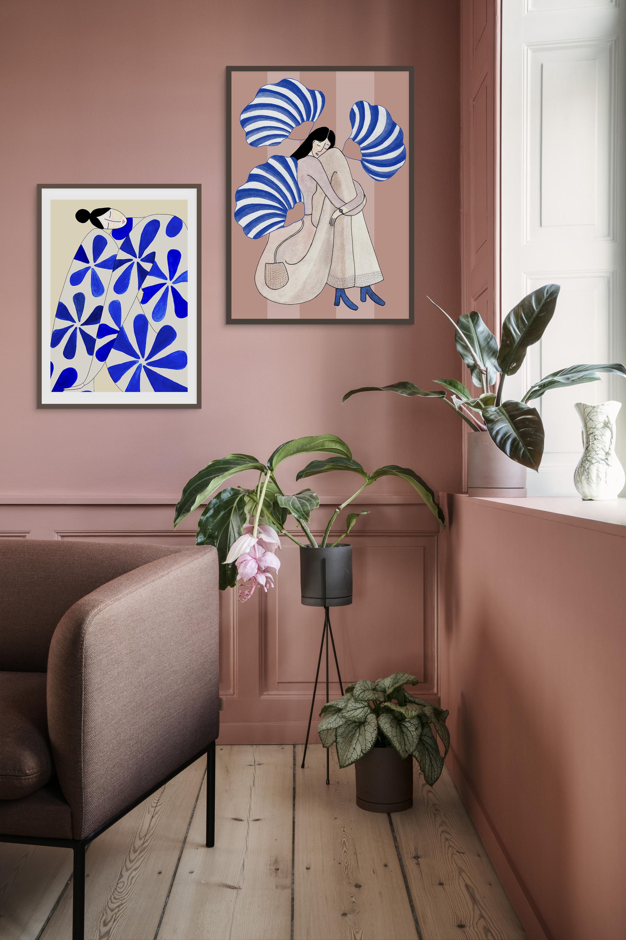 SHY BLUSH og WALLFLOWER kunstplakater i mørke rammer på rosa panelvæg med grønne planter
